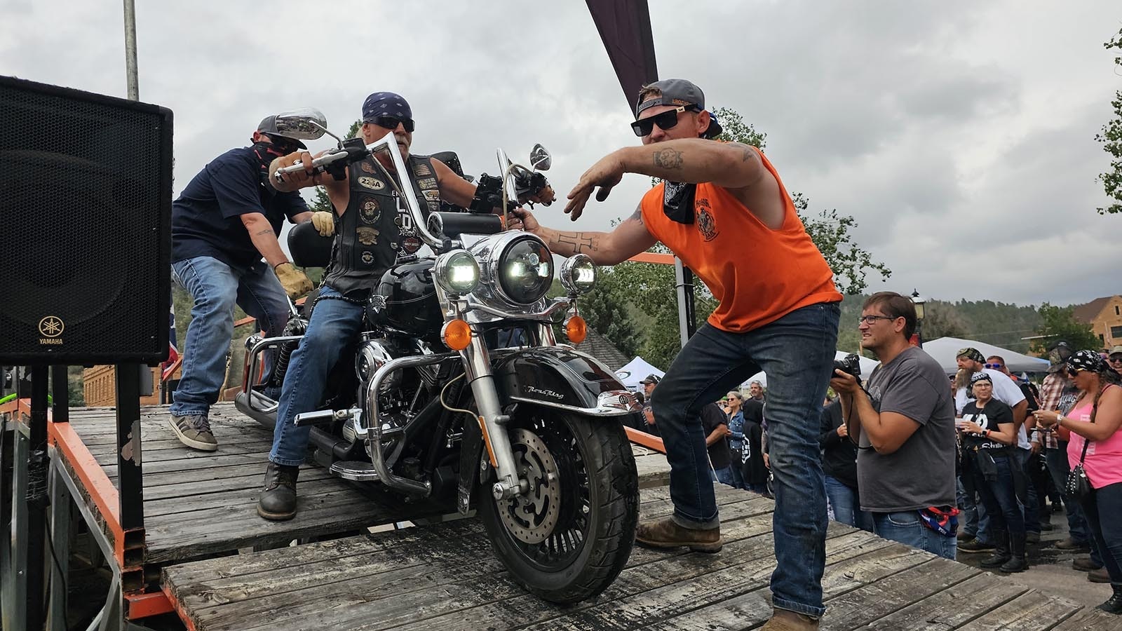 The Burnout team assists a rider in getting his bike off the ramp after burning out the back tire.