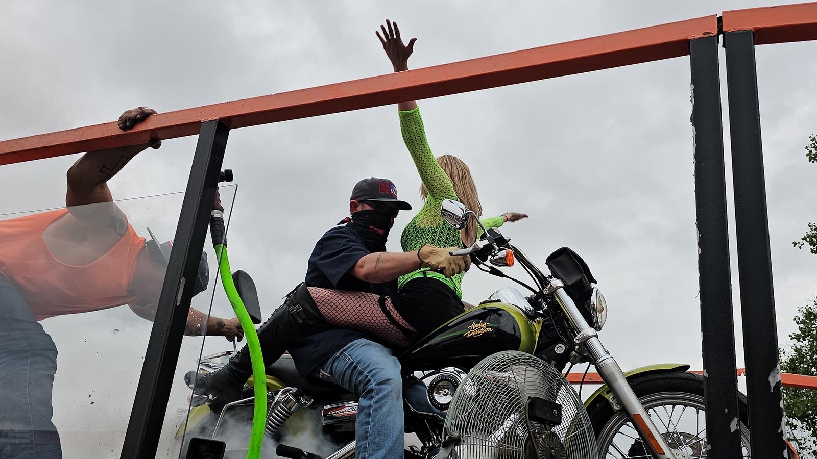 Jess Jones waves her arms up and down at the crowd to rile them up during an exhibition Burnout ride with her husband, Casey.