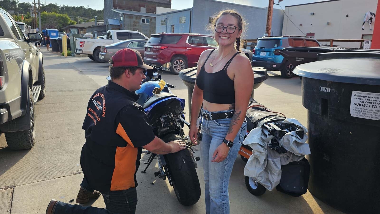 Sierra Goodhouse poses in front of her motorcycle as she waits for a new tire to replace the one she burned out.
