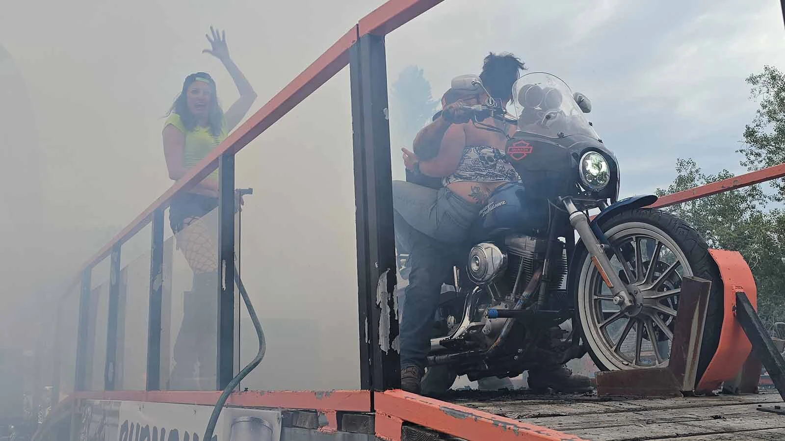 Dime Horseshoe Bar owner Jess Jones urges the crowd to cheer during a burnout ride in Sundance. The contest is held every year during Sturgis Rally week.