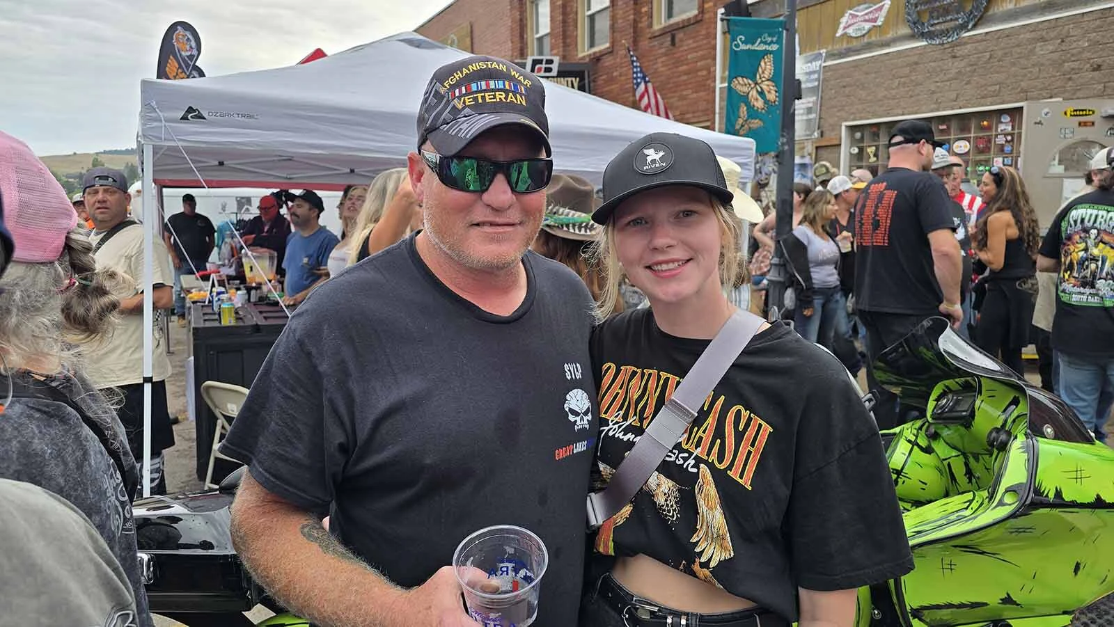 Bill Snider, from Michigan, poses with his daughter Erica Goble in front of the Dime Horsehoe Bar just after winning first place. Snider is a regular in Sundance during the Sturgis Rally week.