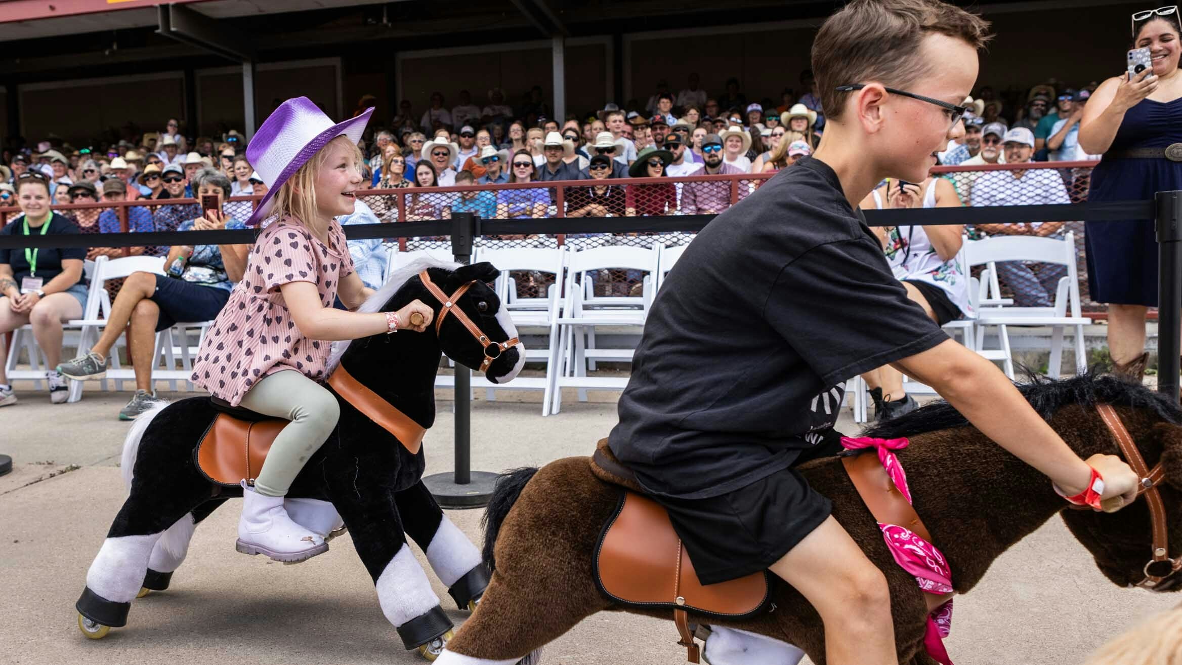 Ophelia Pugh on her black horse from Cheyenne tries to ride her horse into second place to pass up Rogen Hall on the Sorrel horse from Cheyenne during the final stretch of the Kids Horse Race at Cheyenne Frontier Days on July 24, 2023.