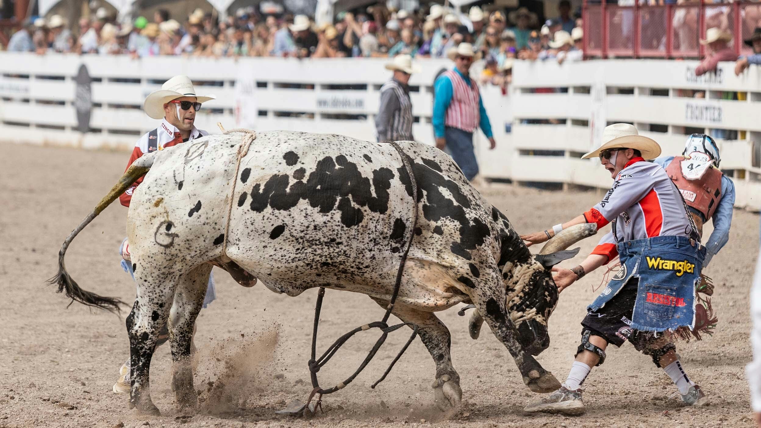 Bullfighters Dusty Tuckness and Cody Webster run into action to protect a bull rider at Cheyenne Frontier Days on July 29, 2023.