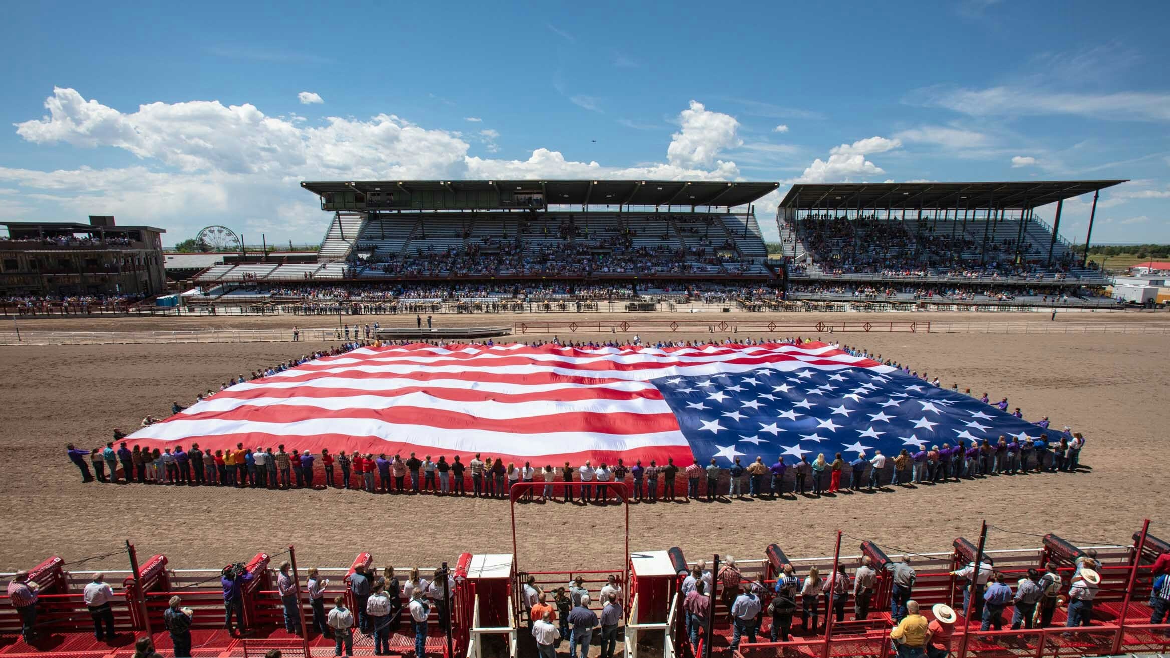 Cheyenne Frontier Days salutes the Military with Military Monday, volunteers hold arena size flag during the National Anthem on July 24, 2023.