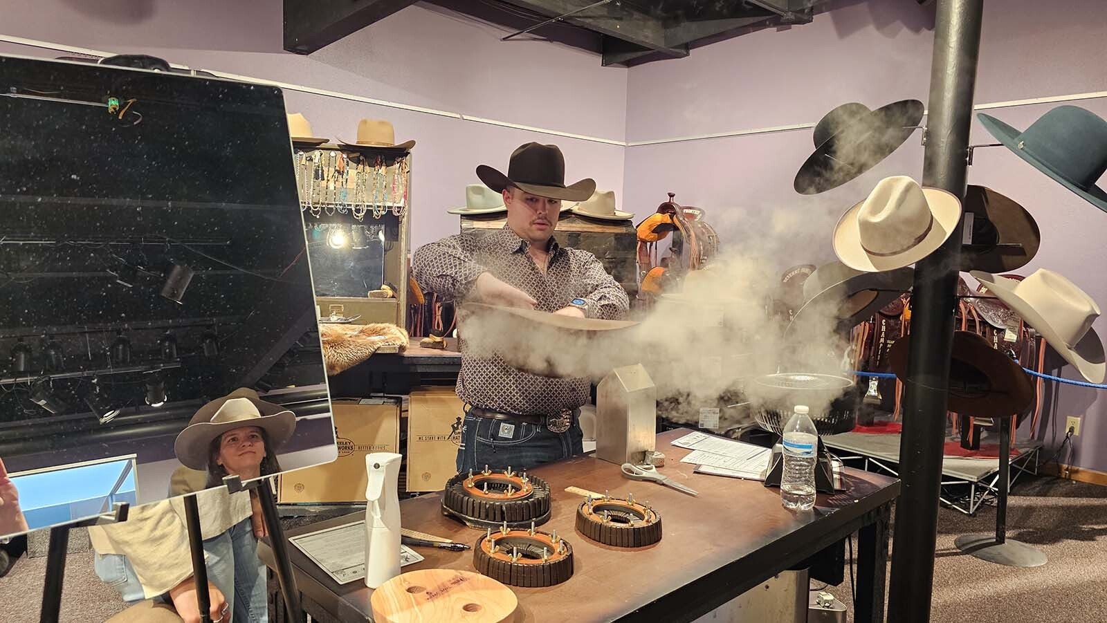 Guy Hamasaki, with Greeley Hat Works, reshapes a hat during the Cheyenne Frontier Days Western Art Show.