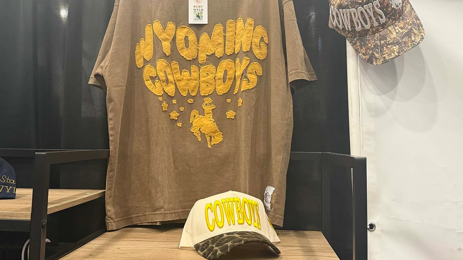 A vintage-inspired “Wyoming Cowboys” shirts and matching caps on display at Ruby Wyld Boutique's booth during the College National Finals Rodeo shopping expo in Casper.