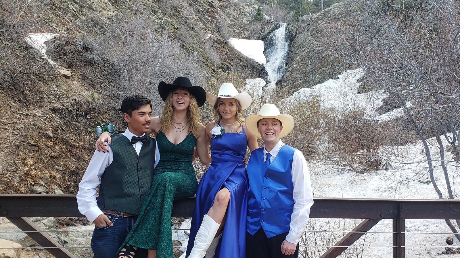 Cadence Kiser and Kota Yann in green pose with Aspen Chambers and Jacz Ellis in blue in front of the waterfall before their prom.