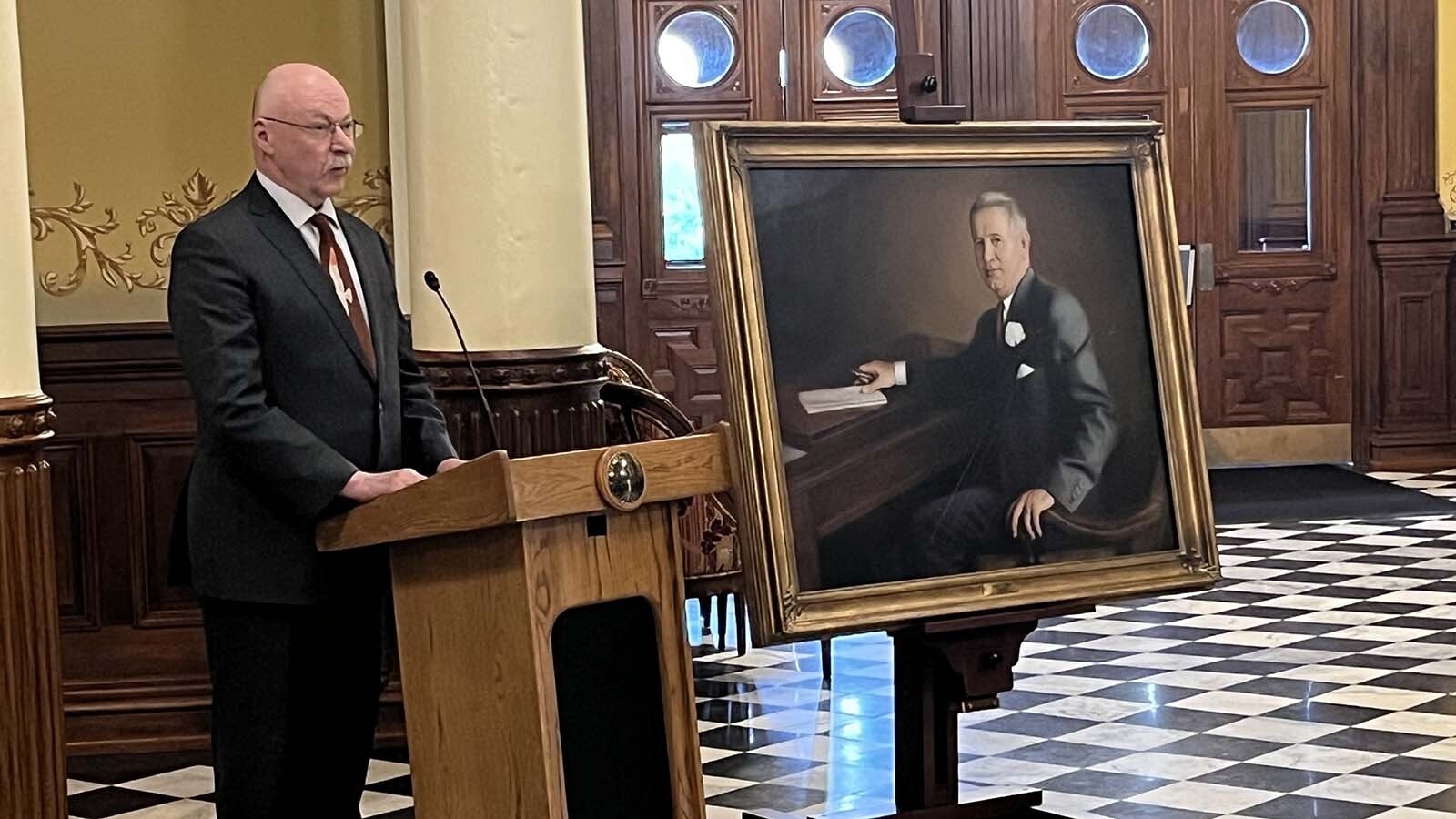 State Sen. Cale Case with a portrait of former U.S. Sen. Lester Hunt in the rotunda of the Wyoming Capitol on Wednesday, June 19, 2024, the 70th anniversary of Hunt's death by suicide.