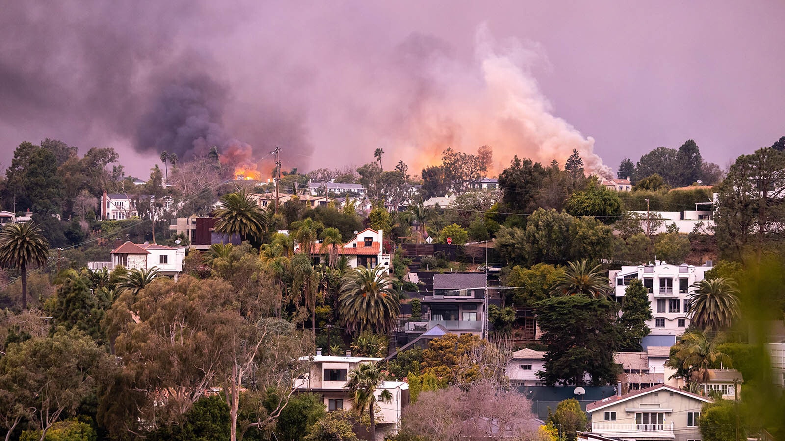 Flames from the Palisades Fire approach homes in Pacific Palisades, California.