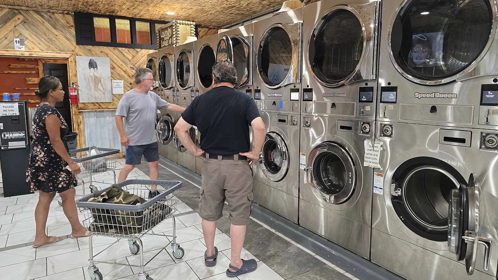 Sophal Thompson helps customers with a washing machine at On-Site Laundry in Lander.