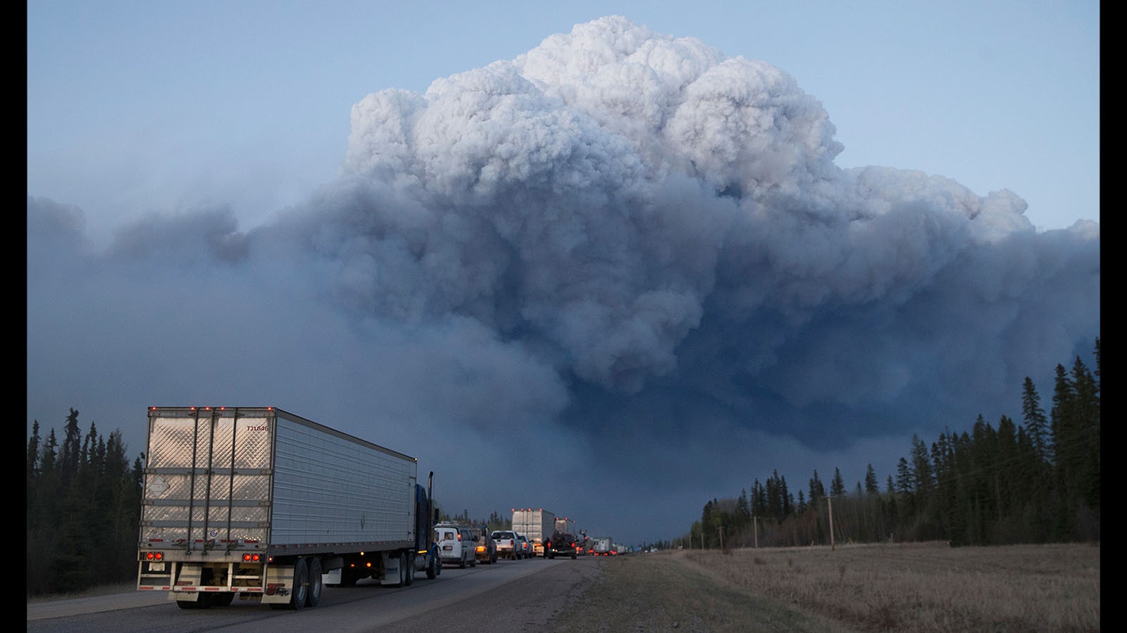 Drivers wait for clearance to take firefighting supplies into town outside of Fort McMurray, Alberta. Wildfires burning out of control forced the evacuation of more than 80,000 residents from the town.