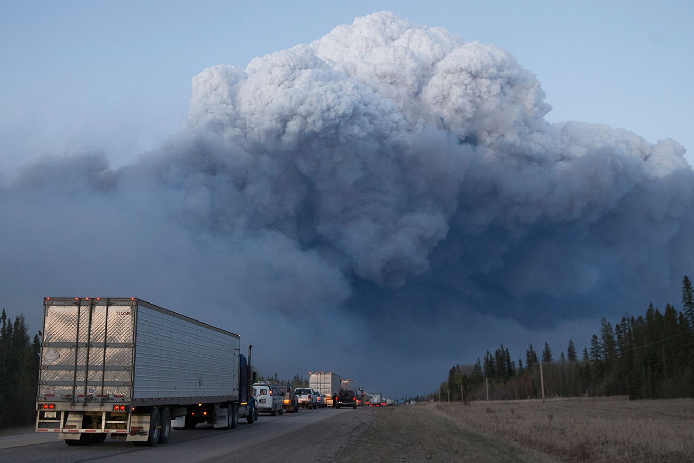 Drivers wait for clearance to take firefighting supplies into town outside of Fort McMurray, Alberta. Wildfires burning out of control forced the evacuation of more than 80,000 residents from the town.