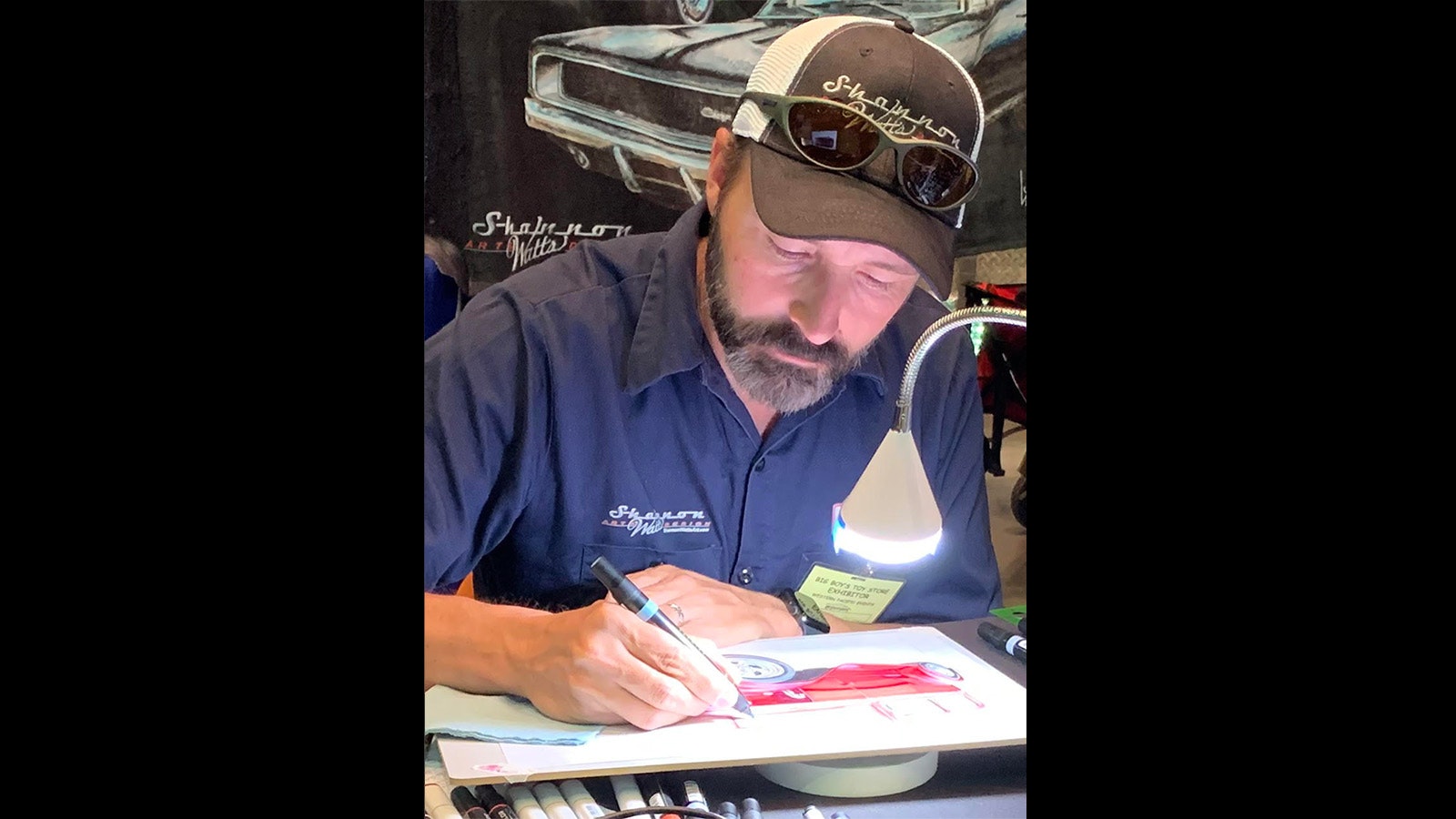 Resident artist at a Reno, Nevada, car show. Shannon Watts demonstrates his technique for fans