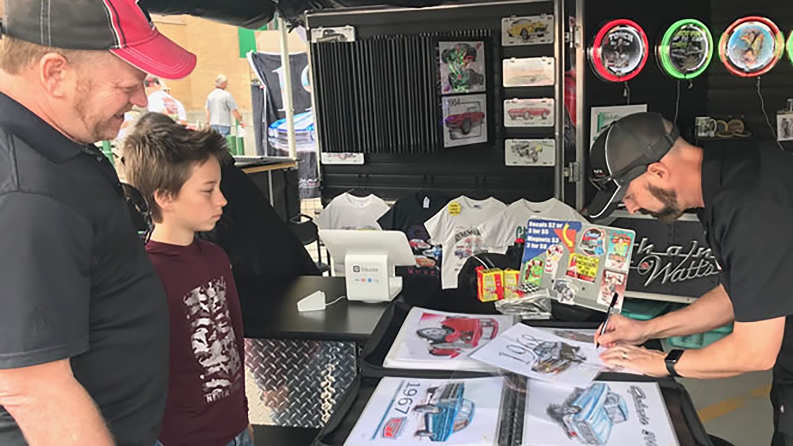 Signing a print of his ’68 Charger for fans at a car show.