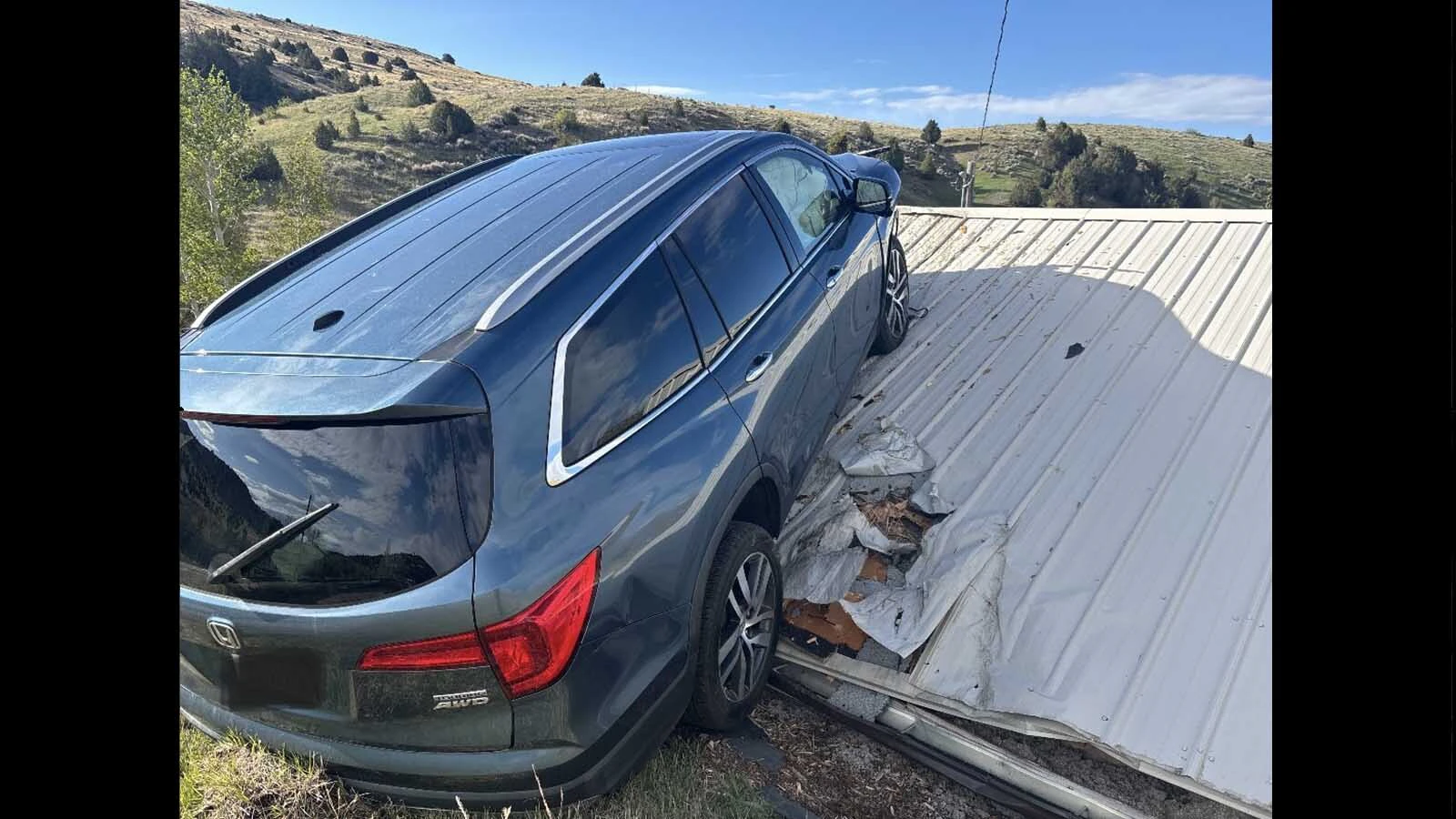 The Montana Department of Transportation had to rescue a driver from an SUV that crashed through a guardrail, toppled down an embankment and landed on the roof of a garage this week. Most people, however, say the real hero is the garage roof.