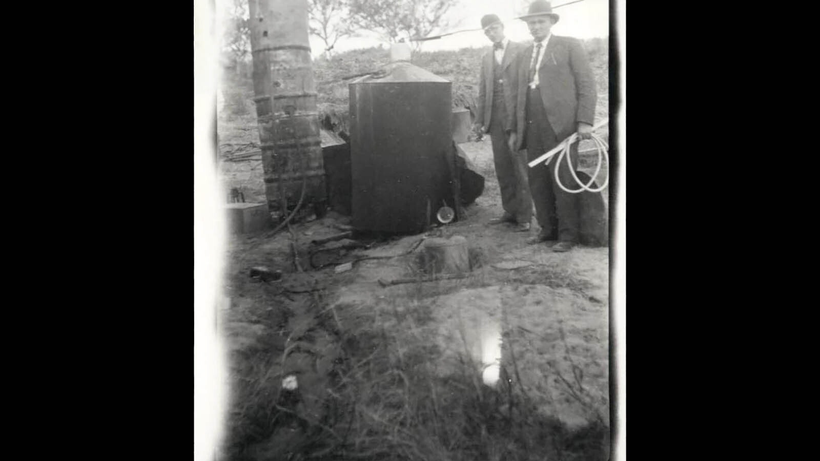 Agents stand beside a still, seized in a raid.