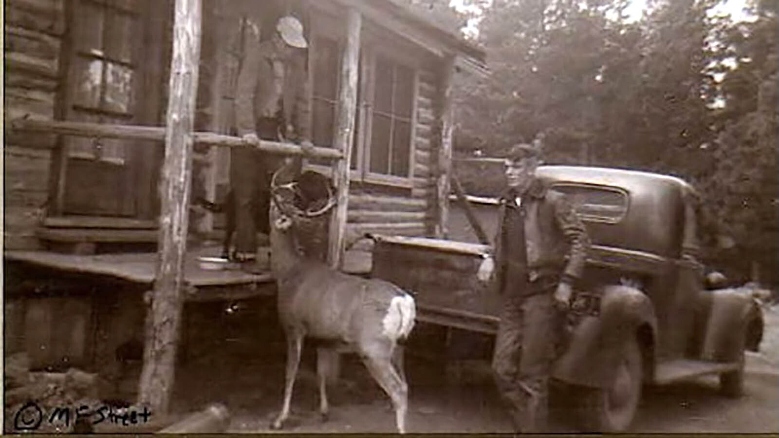 Roy Street, standing by the truck, with his brother on the porch at the Wa-Wa Lodge in the 1940s.