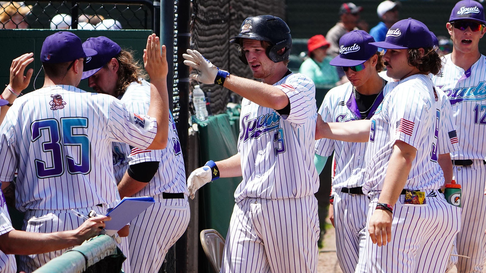 The Casper Spuds celebrate with a teammate after crossing the home plate.