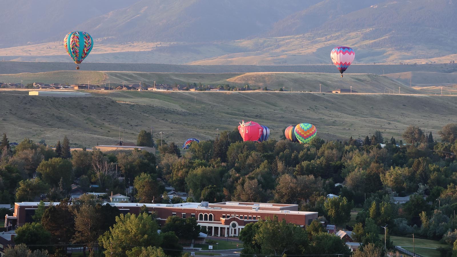 Carmeron Wagner flies his balloon, left, in the early morning above central Casper.
