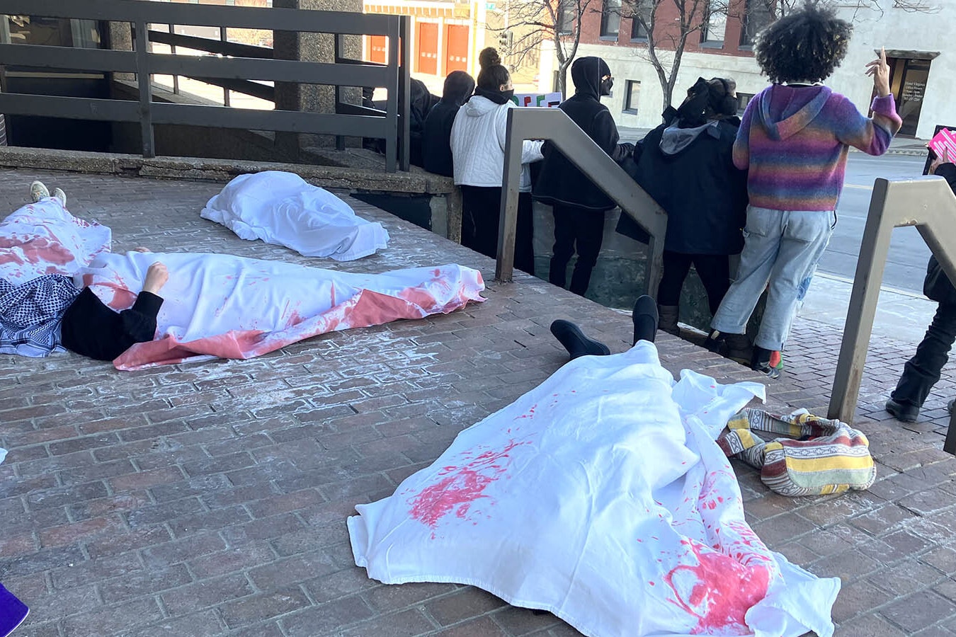 Protesters lay with sheets over their bodies to depict Palestinians who have been killed.