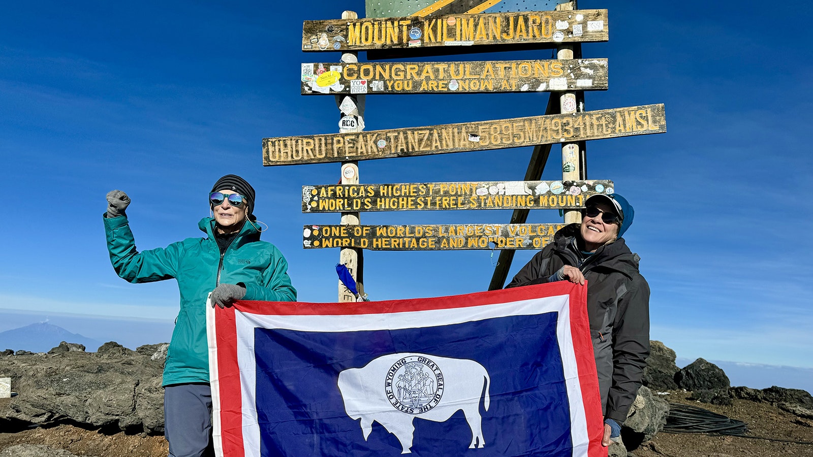 Cathy Blanchard, left, and Deb White of Cody, Wyoming, hold the Wyoming flag at the summit of Mount Kilimanjaro in Africa on Oct. 16, 2024.