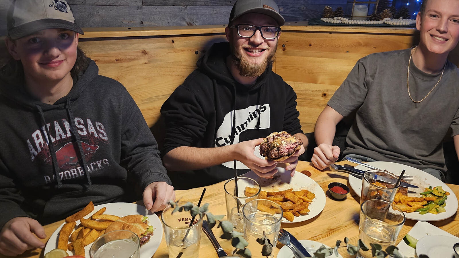 Fabian Corona, center, with friends, enjoyed a last meal at  Cavalryman Steakhouse in Laramie. The burger Corona is holding up is what he calls The Dishwasher Special. It's two 10-ounce patties with five cheeses and bacon bits.