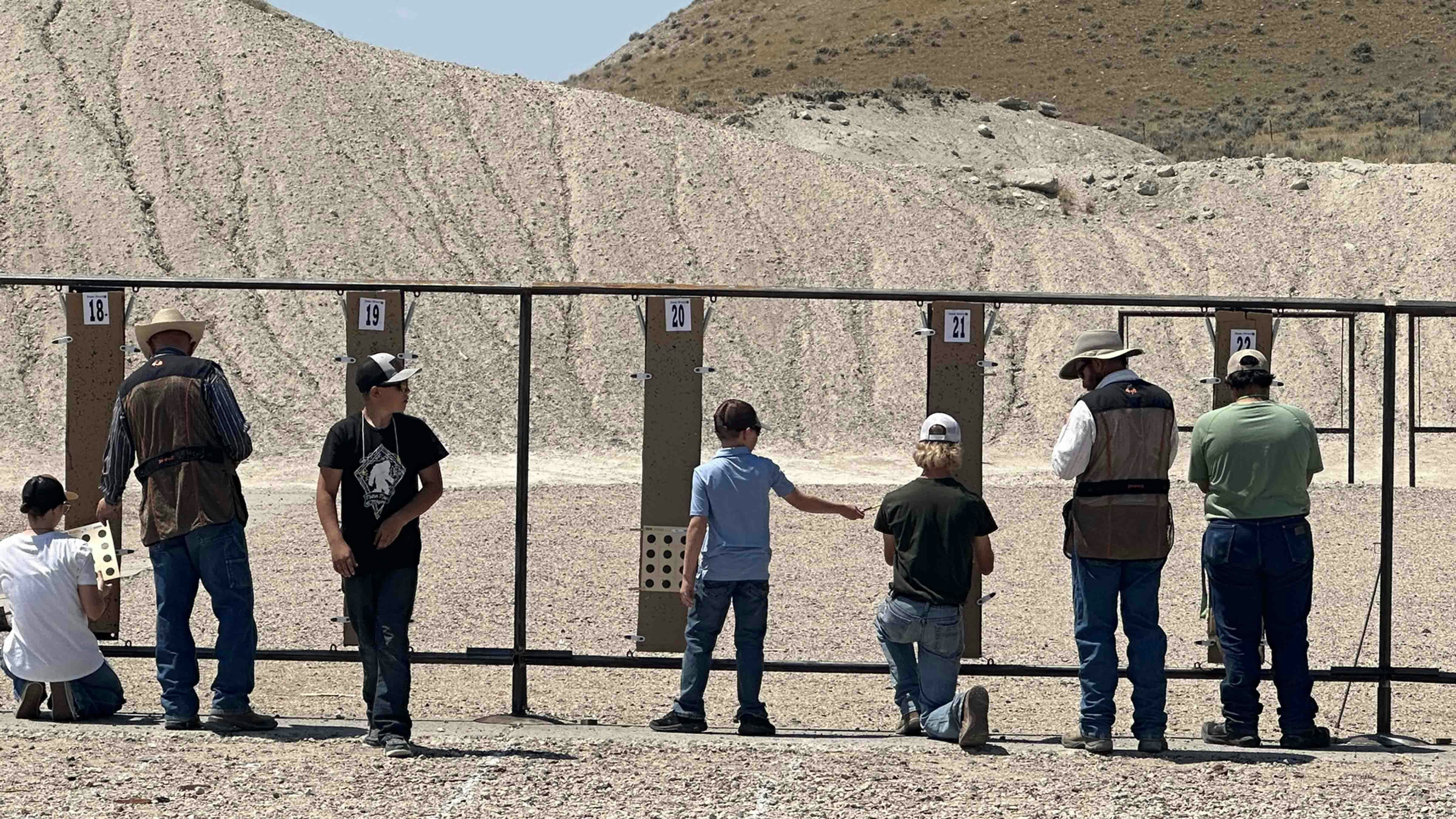 Competitors, ranging in age from 8 to 18, inspect their targets and discuss them with the Range Officials before hanging up their next target