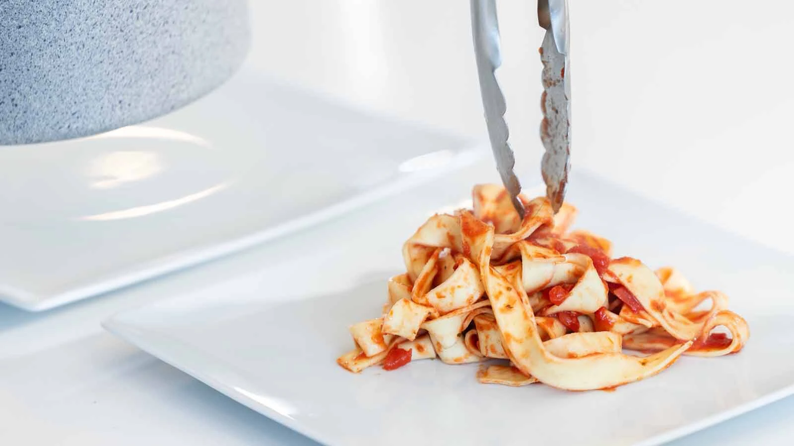 Pasta is plated for a fine-dining experience in a remote location.