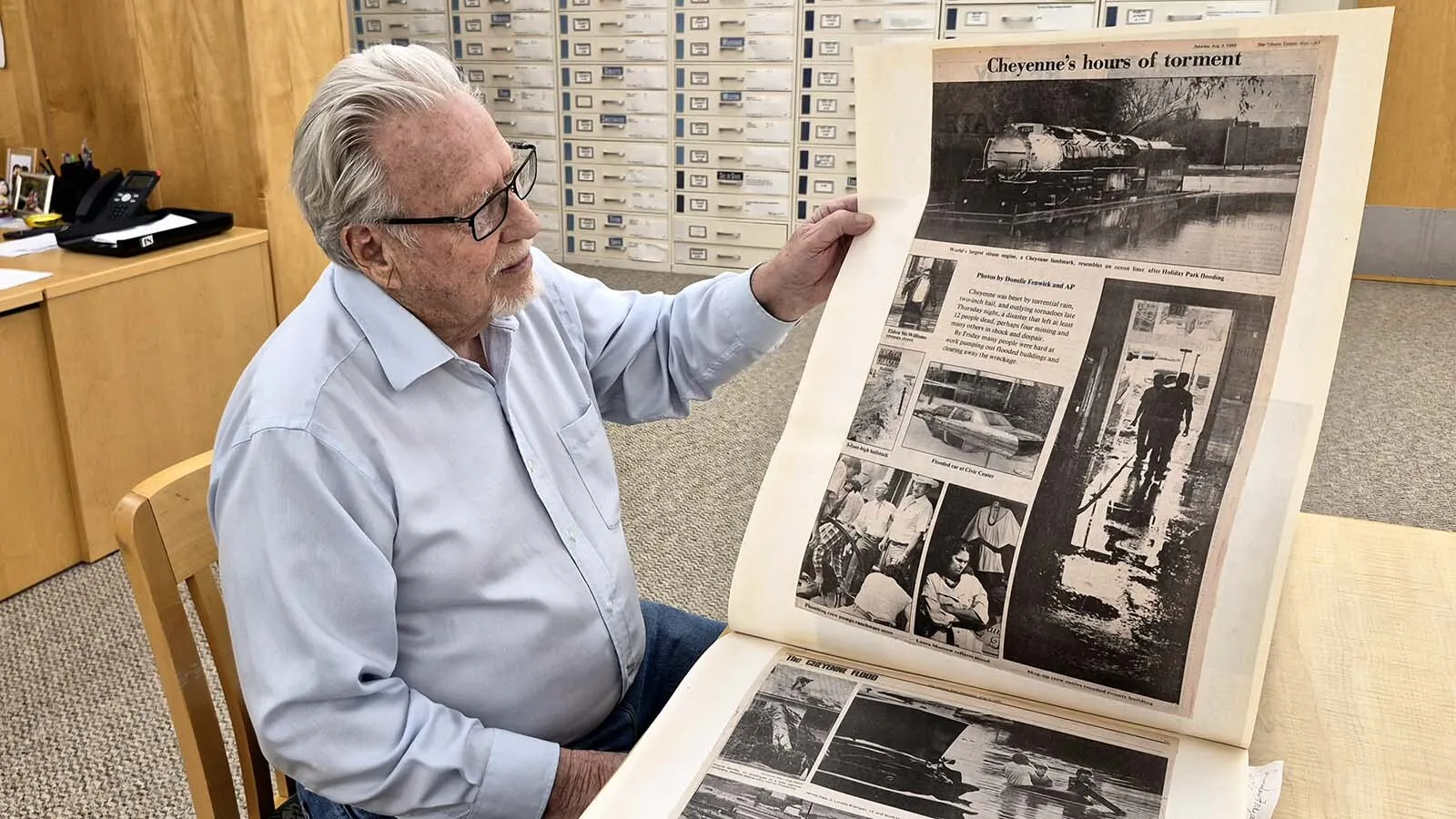 Don Erickson, the 89-year-old former three-term mayor of Cheyenne, examines photos of the city’s deadly Aug. 1, 1985 flood in one of his scrapbooks at the Wyoming State Archives.