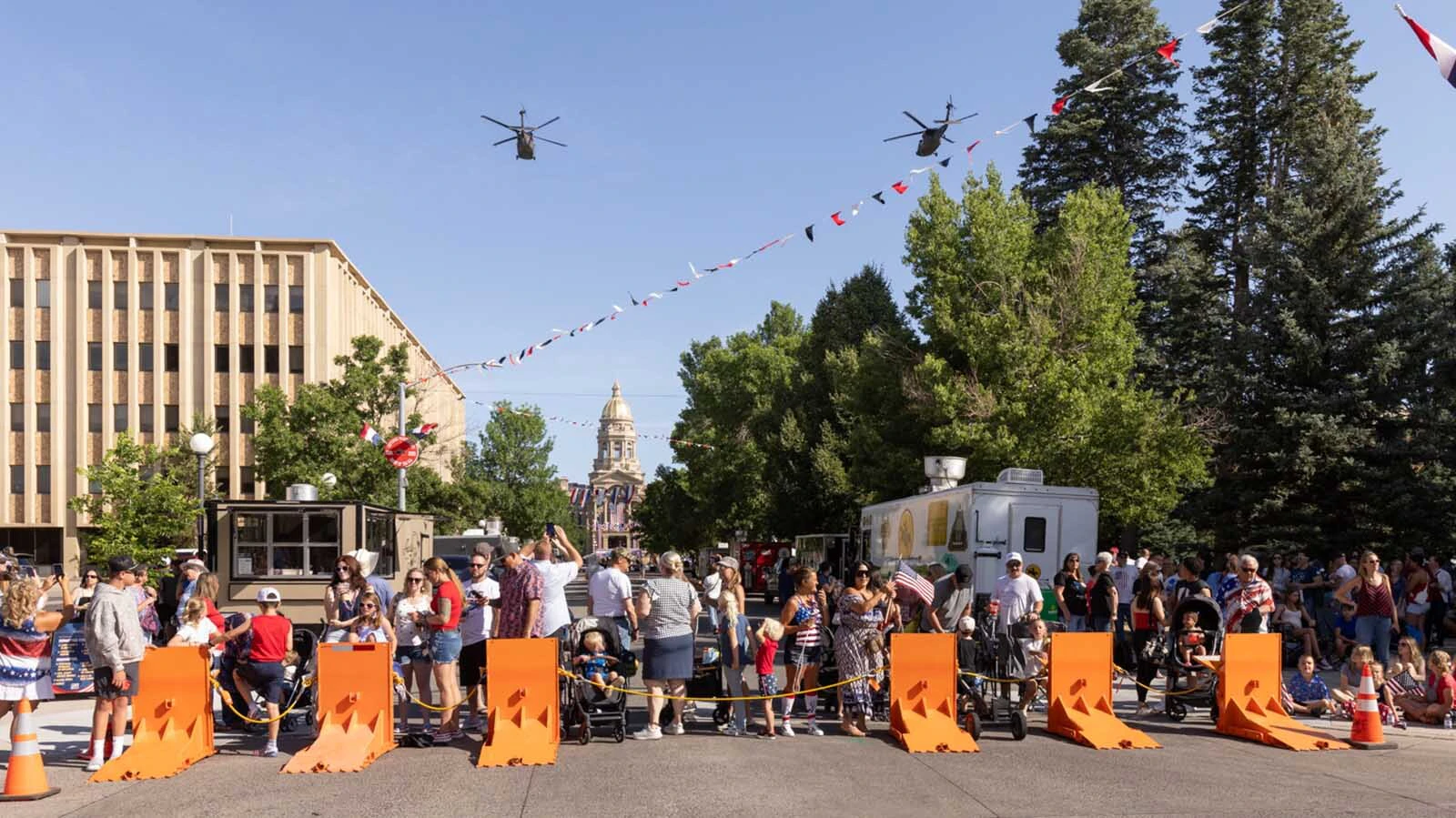 A pair of military helicopters fly over the Wyoming Capitol to signal the start of Saturday's 250th Fourth of July Parade in Cheyenne.