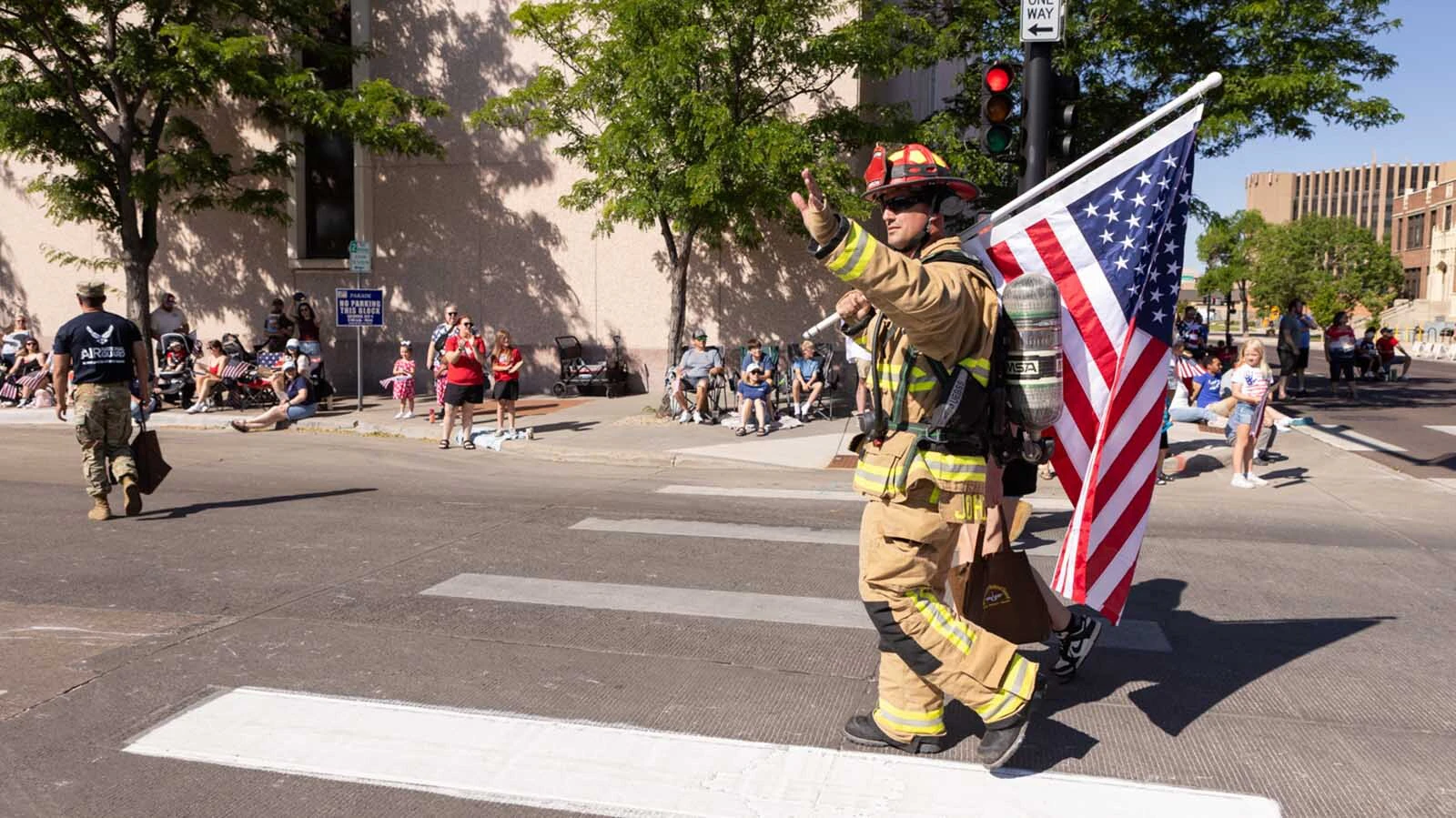 A firefighter carries an American flag in Saturday's 250th Fourth of July Parade through downtown Cheyenne.