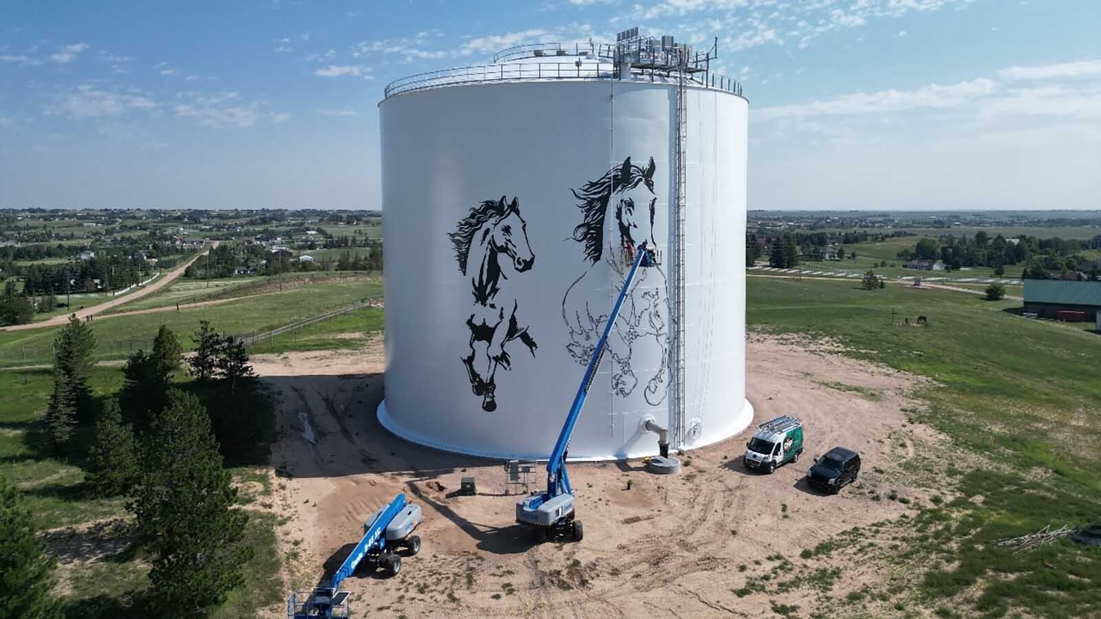 Cheyenne artist Jordan Dean is painting two giant 60-to-70-foot horses as the centerpiece of a stunning mural on a prominent water tank. It takes two giant booms, a projector and $400 a gallon paint.