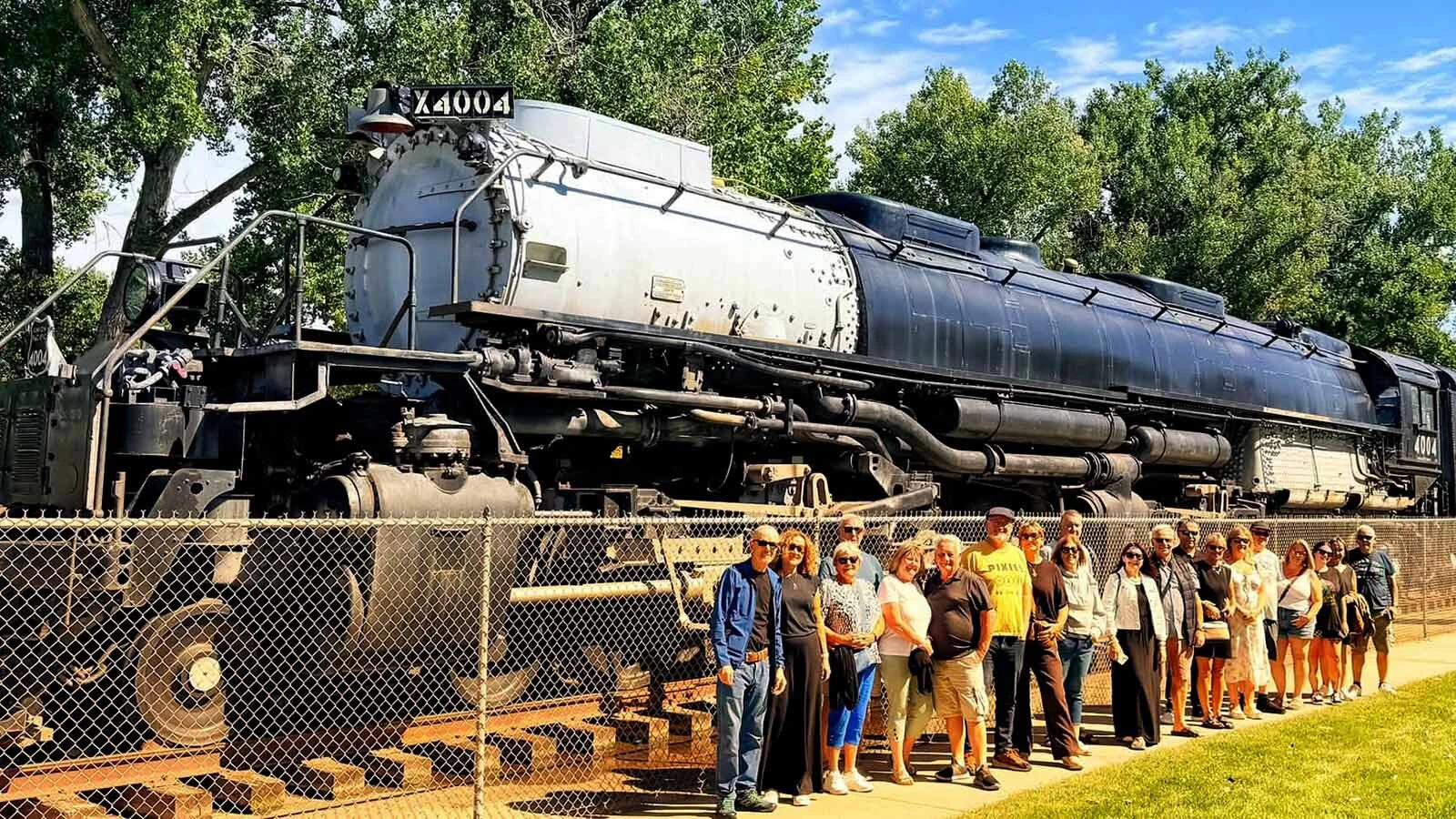 A group of British Irish and Scottish tourists pose in front of Big Boy No 4004 after making an impromptu pit stop as part of the Wild West tour.