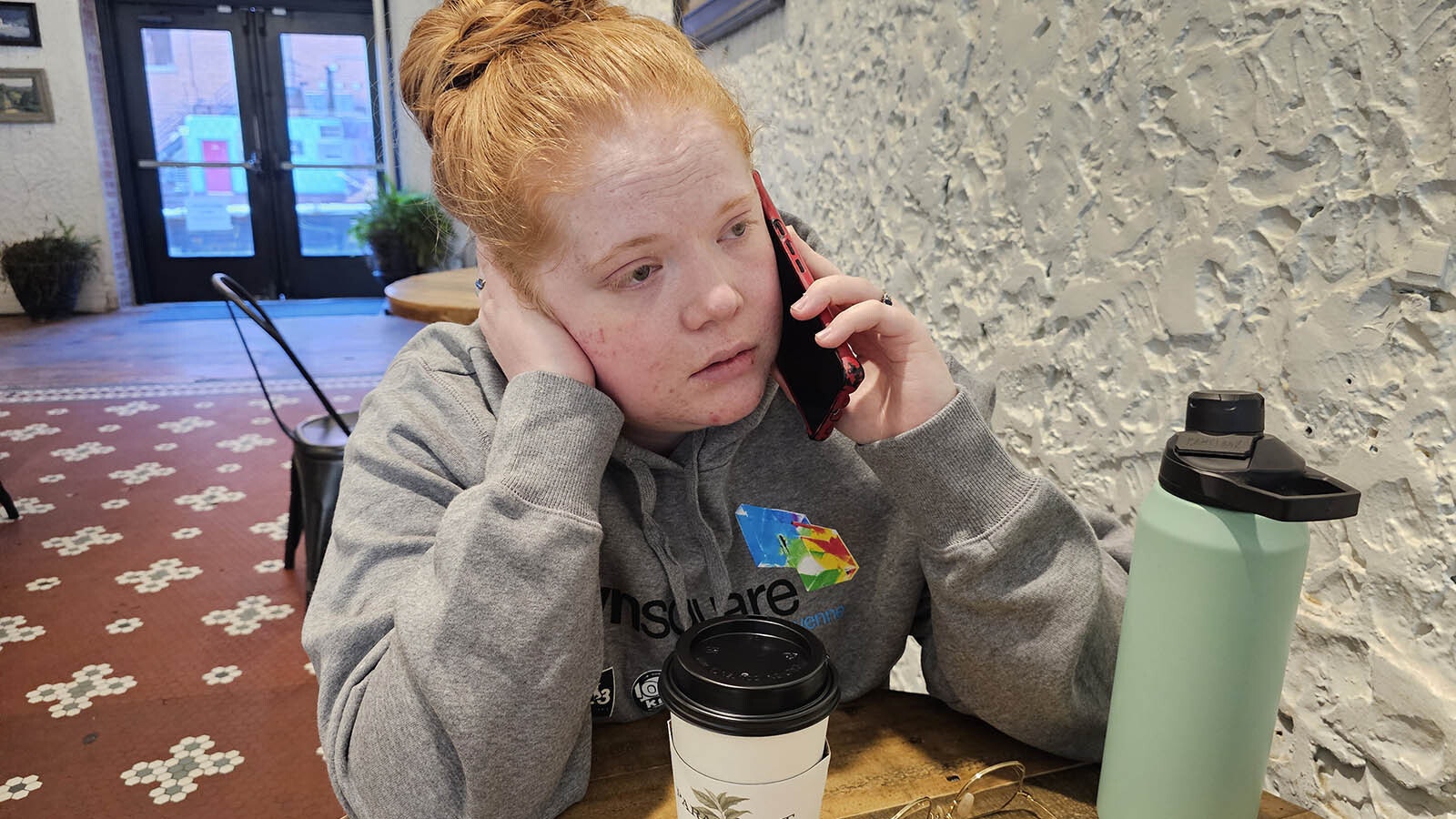 Phylicia Peterson talks with Cheyenne city officials on her smartphone Monday morning about the damage to her home, which was inundated with flood waters after a 12-inch city water main busted last week.