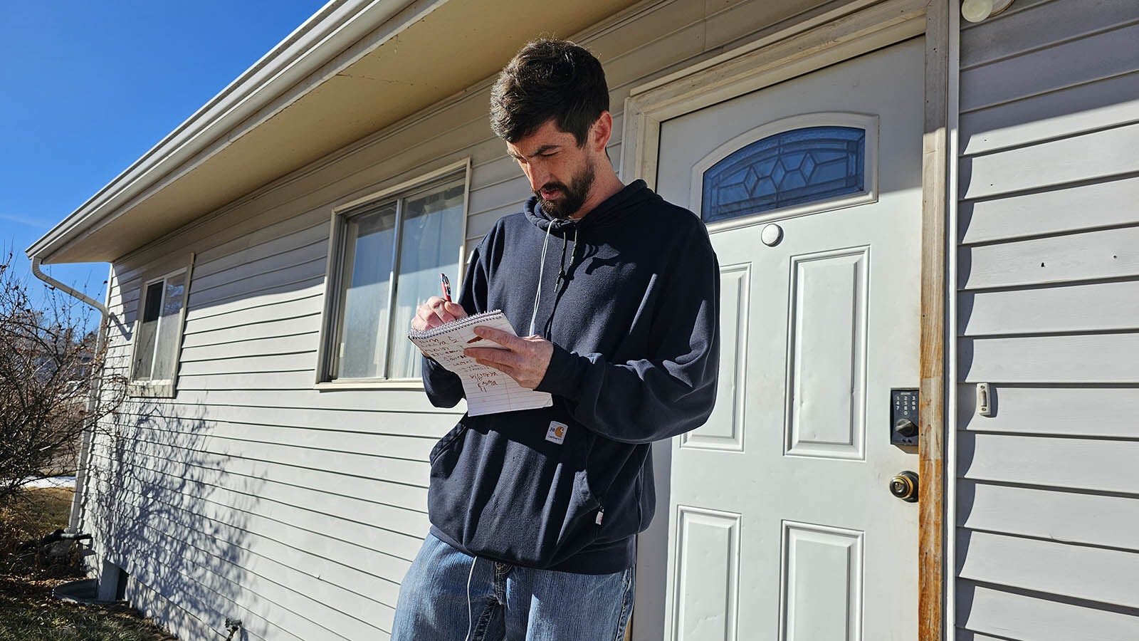Landyn Medina makes a note after visiting one of the households in a neighborhood that was inundated with floodwaters after a 12-inch water main busted in Cheyenne.