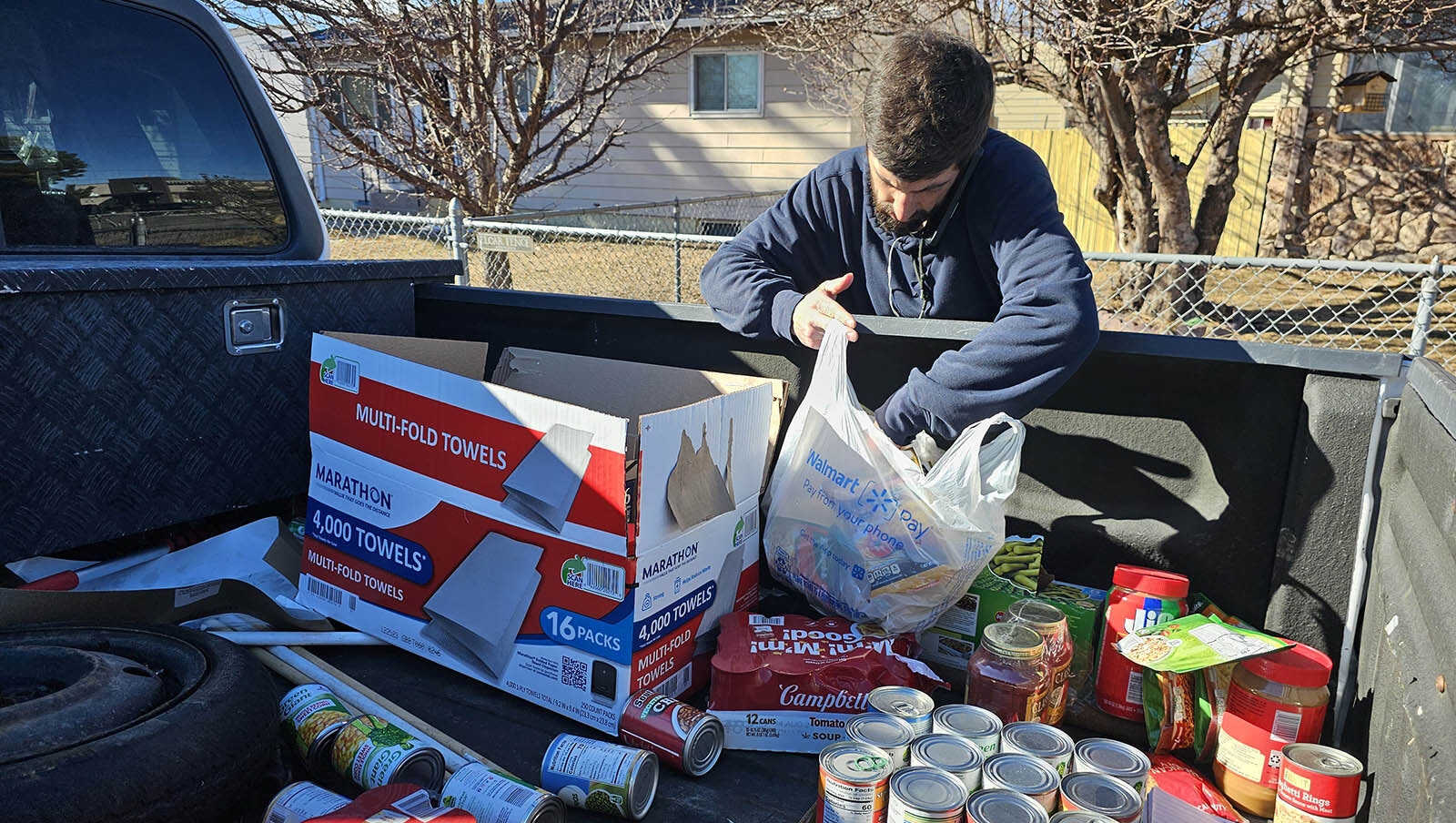 Landyn Medina sorts through some of the food donations he's been given to help Cheyenne families in the Cahill Park area. The families are in danger of losing their homes after a 12-inch water main broke last week.