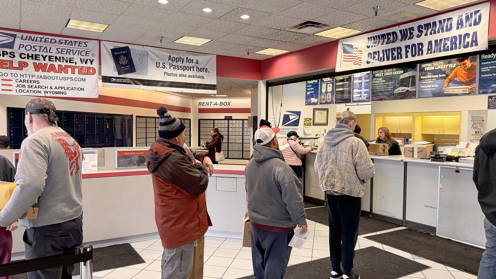 A line of people wait at the Cheyenne Post Office while other customers access their P.O. boxes in the background.