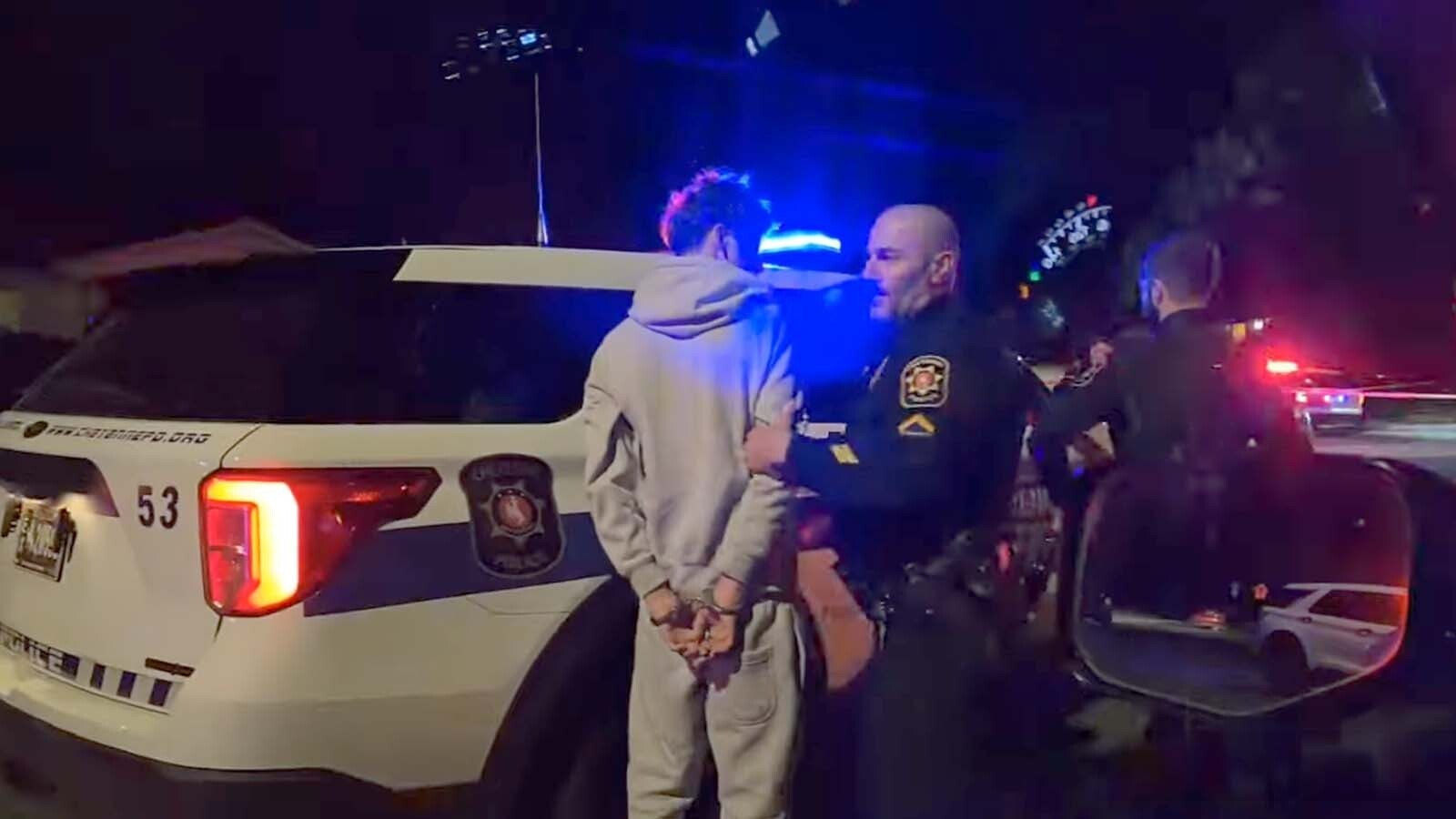 A person is handcuffed and put into a Cheyenne Police Department vehicle at the scene of a fatal shooting Nov. 13, 2025, in northwest Cheyenne.