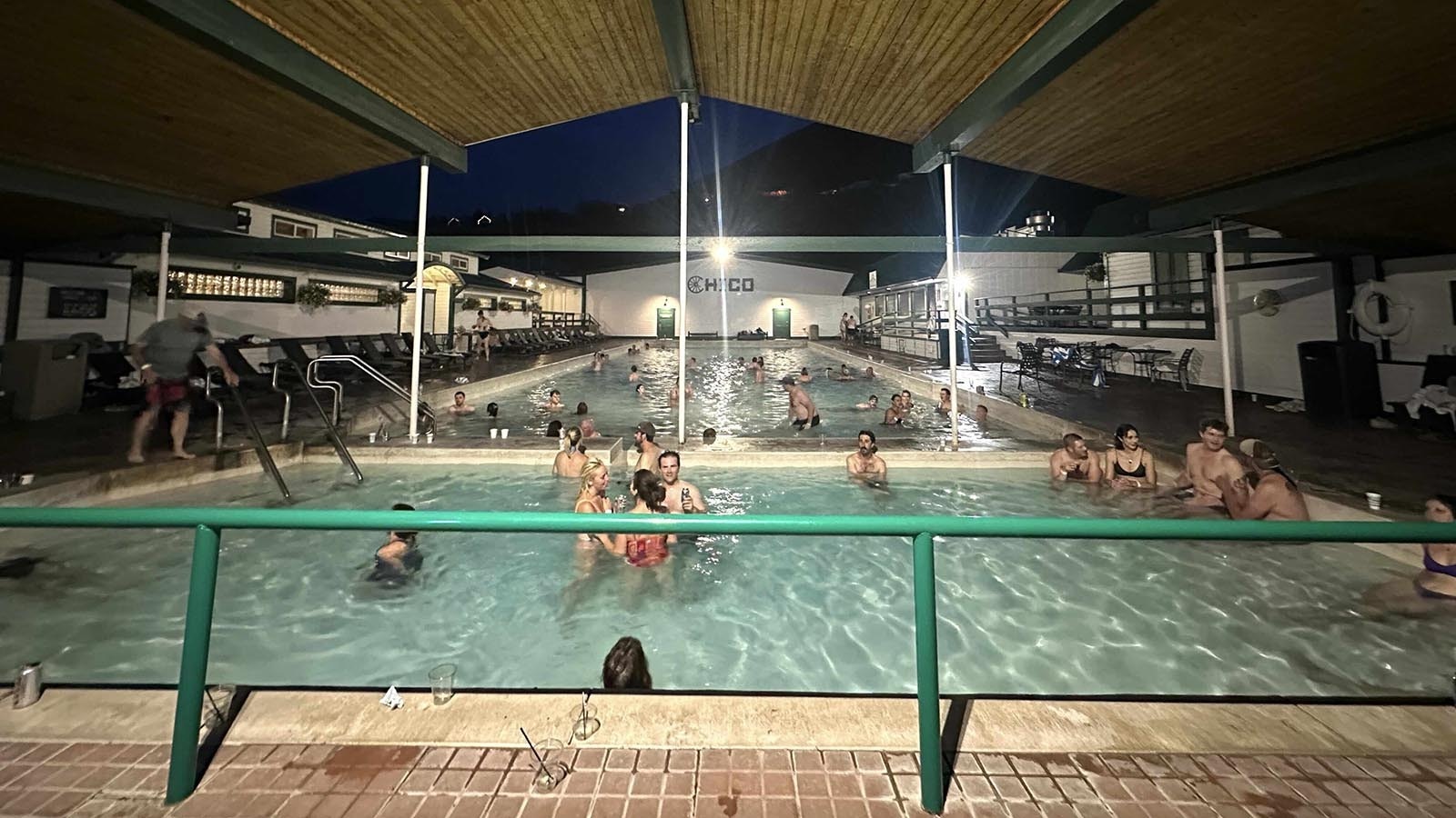 Bartender Rachel Moan accepts dry dollar bills from customers inside and soggy dollars from hot springs customers, who are warned — don’t drink too much, and don’t pee in the pool.