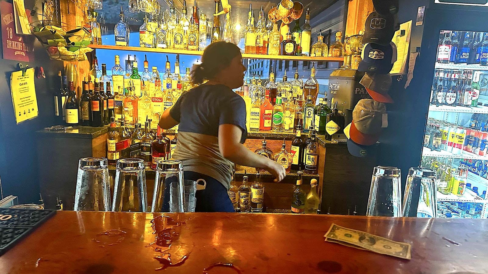 Bartender Rachel Moan accepts dry dollar bills from customers inside and soggy dollars from hot springs customers, who are warned — don’t drink too much, and don’t pee in the pool.