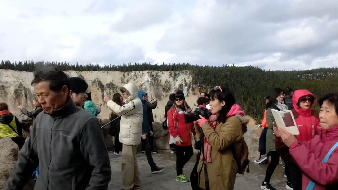 A group of Chinese tourists at an overlook at Yellowstone National Park.