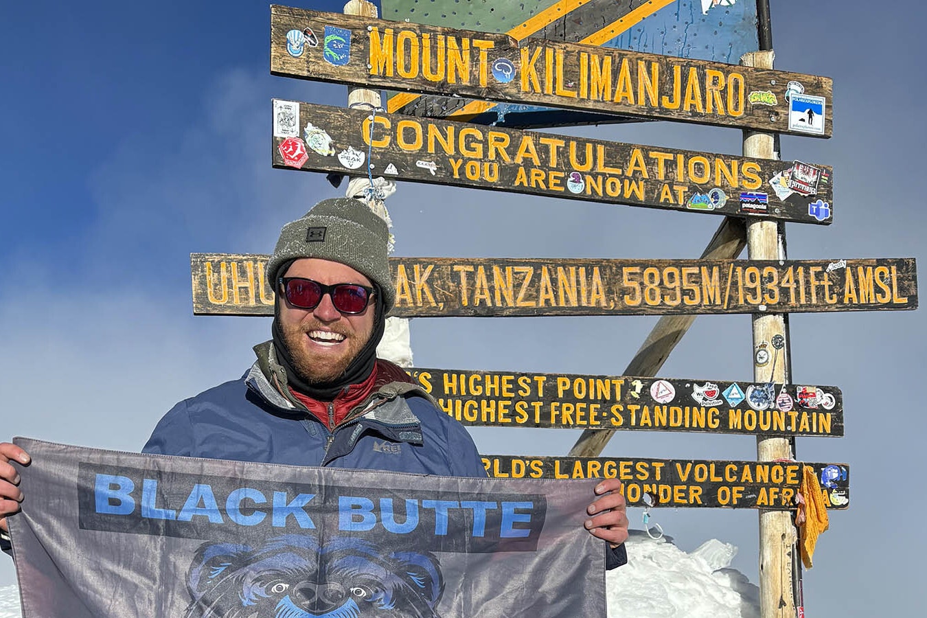 Rock Springs Spanish teacher Chris Clifton shows a Black Butte High School flag at the top of Mount Kilimanjaro.