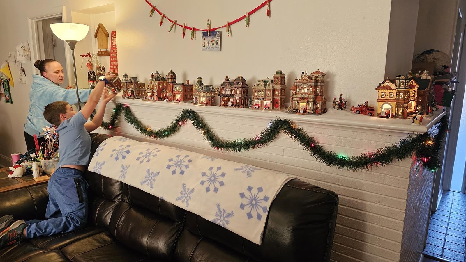 Brittany Bartow helps her son Carsen adjust a Christmas fire station house, part of the family's indoor holiday decor.