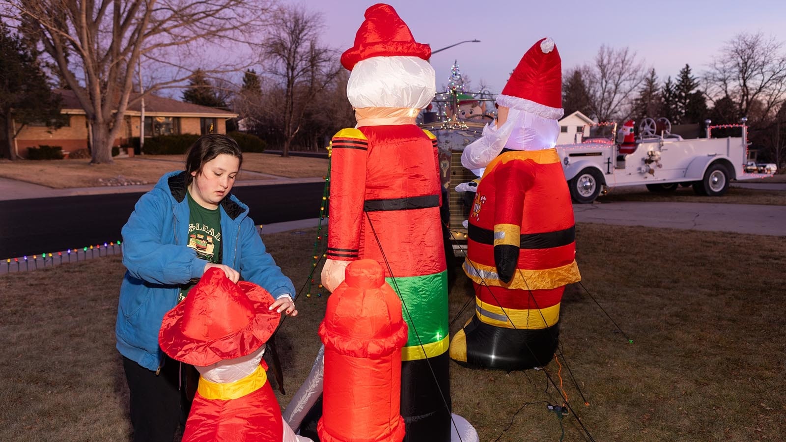 Paige Bartow straightens up inflatable decorations after a windy day in Cheyenne.