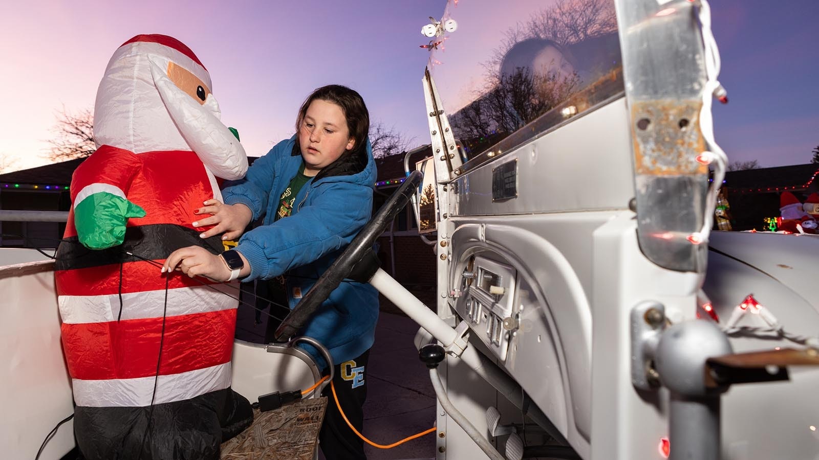 Paige Bartow tightens the ropes of the inflatable Santa in the 1938 Studebaker fire truck to ensure everything is ready for Christmas light display viewers in Cheyenne, Wyoming.