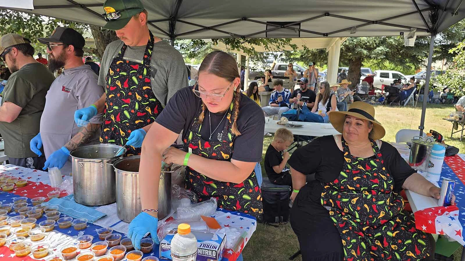 Amy Kennison looks on while family members place samples of chili out for the long lines of people coming through to taste their red and green chilis.