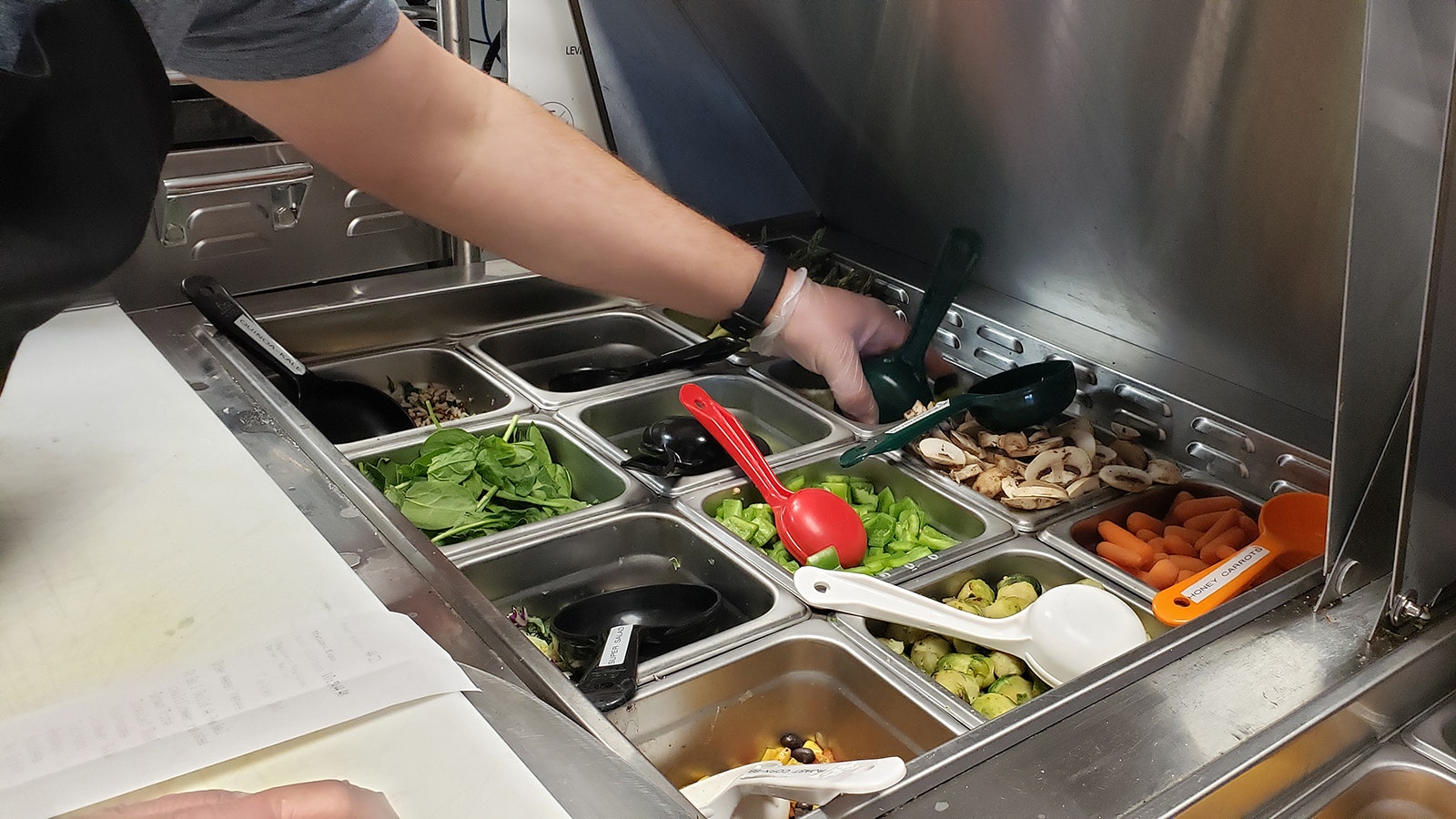 Ingredients for build-a-bowls and wraps are arranged sandwich artist style for quick service prep.