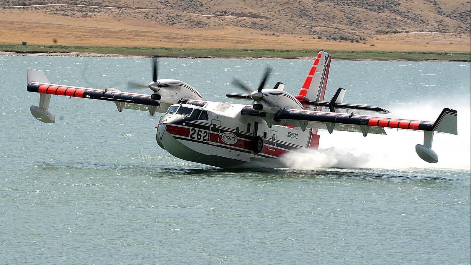 A tanker plane dips low into Buffalo Bill Reservoir, loading up with water to drop on a Wyomihng wildfire.