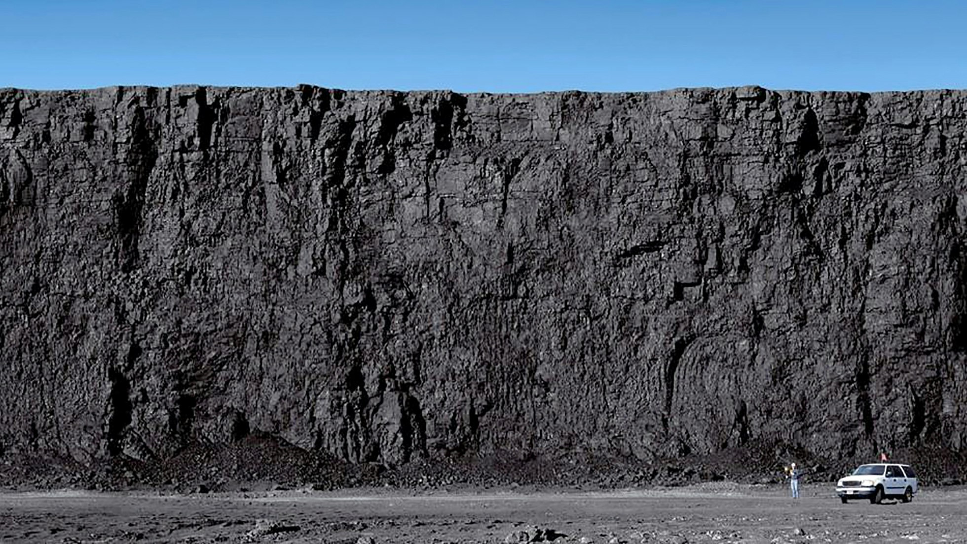 A man standing next to an SUV gives perspective to this huge exposed coal seam at a Powder River Basin mine.