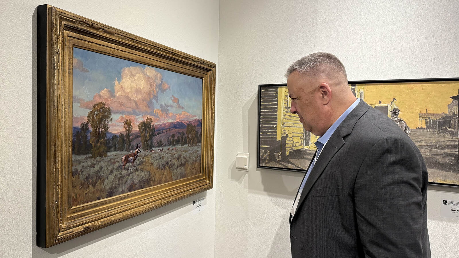 Judge Scott Leinen examines "Evening Finale," an oil painting by Chad Poppleton while judging the 104 pieces in the 43rd Buffalo Bill Art Show and Sale. This painting received one of five Awards of Excellence from the three judges.